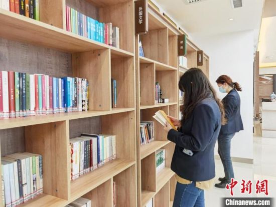 圖為在甘肅公航旅建設(shè)集團(tuán)有限公司的職工書屋，職工挑選書籍?！⌒煅?攝