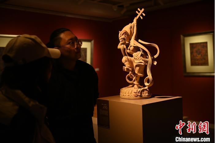 圖為季茂杰向參觀者介紹自己創(chuàng)作敦煌木雕的過程。李亞龍 攝</p>
<p>